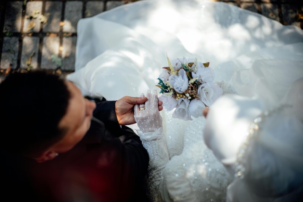 An intimate overhead view capturing a bride and groom during their wedding ceremony, featuring a beautiful bouquet.